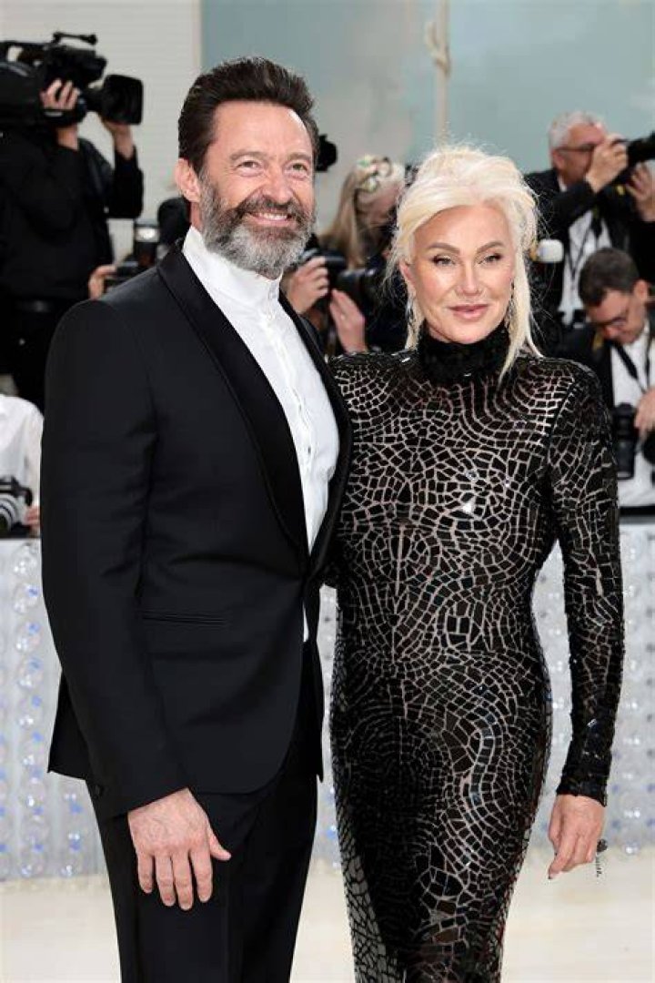Hugh Jackman and wife Deborra-Lee Furness wearing black suits with satin lapels