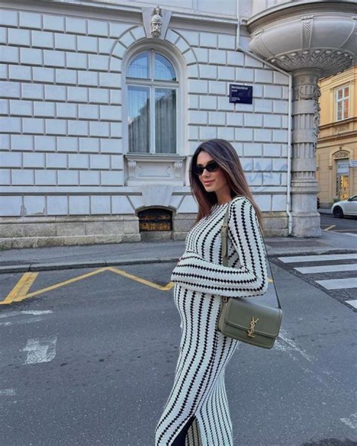 Pregnancy style: The model teamed her jumper with a teddy fleece lined tan coat which she wore with slouchy patchwork jeans and chunky white Prada shoes.